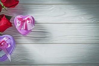 Heart-shaped metal present boxes red roses on wood board holidays concept