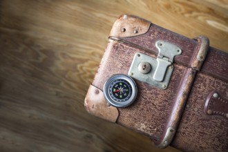 Old vintage suitcase with a compass seen from above, concept for travel, adventure and finding the
