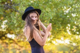 Portrait of a beautiful girl against a background of blurry foliage, the girl temptingly covered