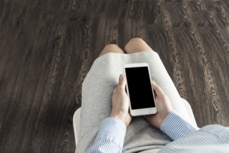 Business woman with cell phone on her lap