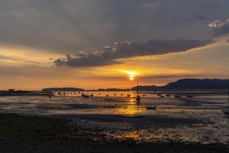 Landscape view of the Menai Strait with many boats at anchor and the mountains of Snowdonia behind
