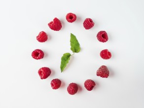 Clock made of berries leaves and raspberries. Isolated on white. Top view or flat lay. Health,