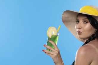 A teenager with an alcoholic drink in her hand and a large hat basks in the summer sun