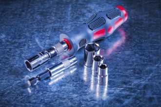Screwdriver bit holders replaceable torxes on scratched metallic background construction concept