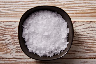 Maldon sea salt flakes in a bowl on a wooden board