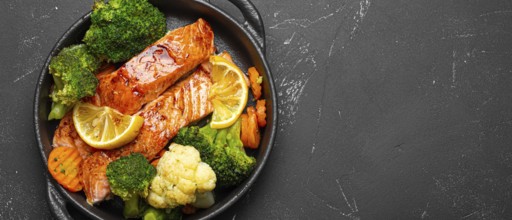 Healthy baked fish salmon steaks, broccoli, cauliflower, carrot in cast iron casserole bowl black