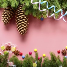 Flat lay design of Christmas greeting card of fir twigs cones, paper streamer, candies and spices