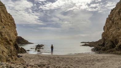 A picturesque small beach in a rocky cove with reef at low tide