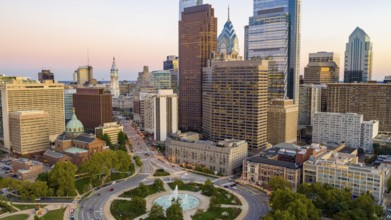 Vehilce traffic circles around the fountain at Logan Square in the bustling urban core of