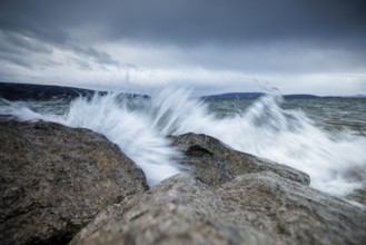 Waves crashing against rocks with dramatic sky in the background, harbour, Mittelzell, Reichenau,