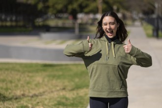 Young woman with happy expression and thumbs up