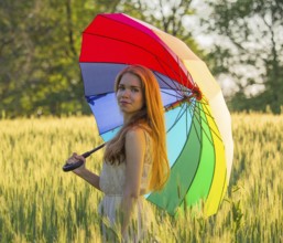 Portrait of a cute girl with a multicolored umbrella
