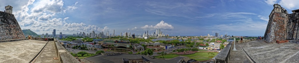 Panoramic view of a cityscape from a historical fort with a mix of urban buildings and greenery