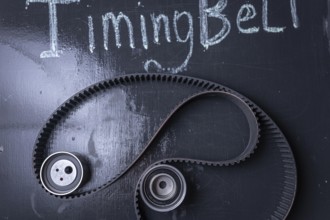 Timing belt on a blackboard with chalk writing and gears