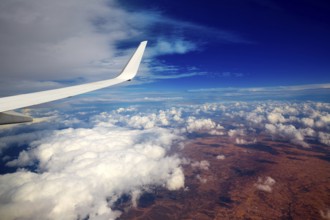 Aircraft wing in a cloudy stormy clouds sky flying