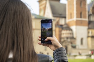Female traveler in historical places looks around courtyard of landmark and shoots short video on