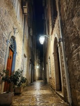 Ancient narrow street of a small medieval town illuminated by lanterns.