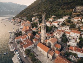 Bell tower among the old houses in Perast coast. Montenegro. Drone.