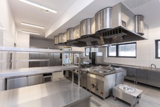 A contemporary commercial kitchen featuring stainless steel appliances and bright, efficient
