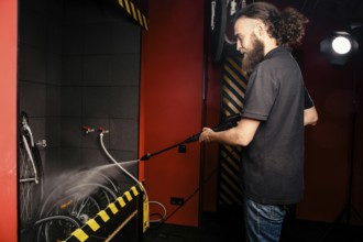 Services professional washing of a bicycle in the workshop. Close-up of hand Young Caucasian