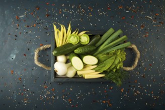 FRESH VEGETABLES ON WOODEN BOX ON A DARK STONE BACKGROUND. THE CONCEPT OF VINTAGE. THE YOUNG CORN