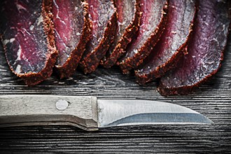 Sliced meat knife on wooden board food concept