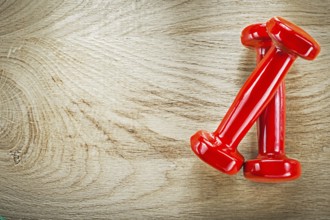 Red dumb-bells on wood board directly above sports training concept