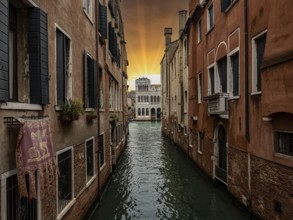 Typical canal of Venice with San Marco flag