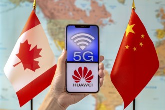 Calgary, Alberta, Canada. Sep 8, 2020. A person holding an iPhone with a 5G and Huawei logo on the