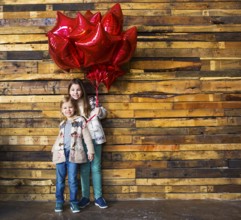 Children with balloons at wooden wall