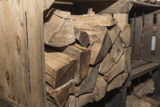 Old wooden box for storing logs ready for the stove - close-up of firewood