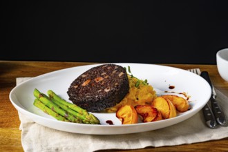 Black pudding with green asparagus and roasted apple