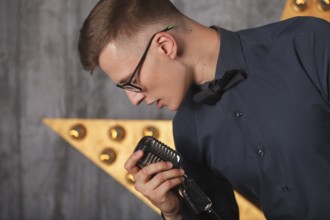 Young man singing with vintage microphone