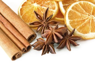 Cinnamon sticks, anise stars and orange slices on white background Cinnamon sticks, anise stars and