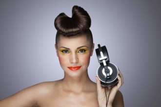A beautiful photo of a beautiful girl holding headphones in her hand
