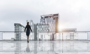 Young businesswoman in suit at balcony against morning cityscape background