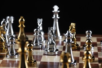 Gold and silver chess figures standing on chessboard. Intellectual and tactic game. Strategy