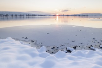 Snow-covered shores of a frozen lake at sunset, quiet and peaceful atmosphere, Seegarten,