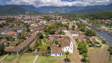 Aerial view to historic town Paraty with tidal river and green mountains in background on a sunny