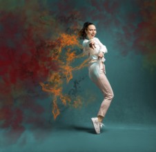 Young and beautiful dancer posing in the studio in front of a colourful background