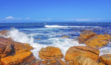 False Bay rough coast landscape with boulders waves and mountains with clouds in Glencairn Simons