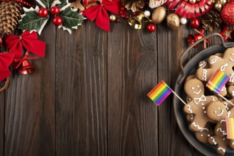 Christmas background of tray with gingerbread cookie men and rainbow flags on wooden table