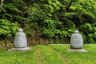 Haeinsa-gil, South Korea. May 26, 2020: Two Buddhist urns on lush lawn in front of mountain forest
