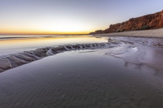 Sea with reflection at low tide in the calm waters of the Atlantic. Landscape shot of the sunset on