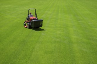 Mowing grass at the football stadium in Lubin, Poland, Europe