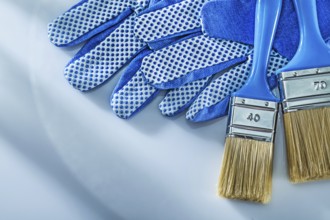 Protective gloves paint brushes on white background