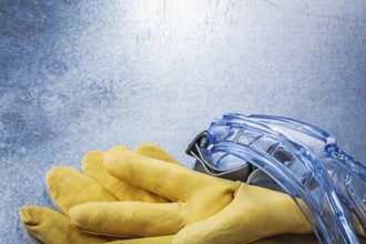 Set of safety goggles gloves on metallic background construction concept