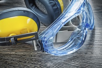 Protective spectacles earmuffs on wooden board