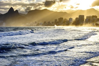 Summer sunset with cloudy sky with Two Brothers hill and Vidigal slum view from Ipanema beach at