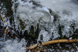 Close-up of icicles on moss-covered stones, The icy waterfall in the Perlbach valley near Bogen,